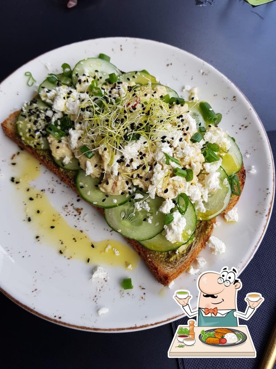 Tartine d’avocat sur pain de seigle, feta, concombre et pousses fraîches.