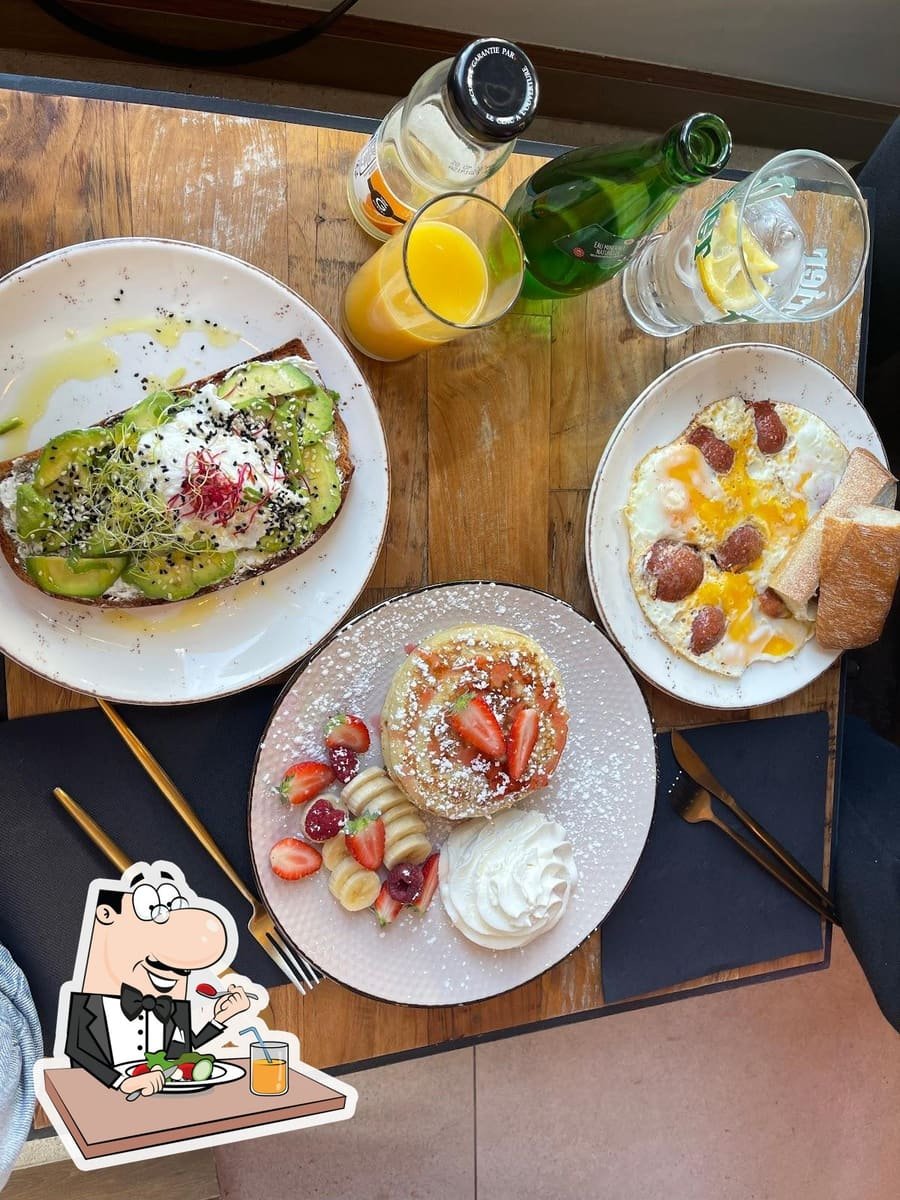 Brunch complet : crêpes, fruits frais, œufs et jus d’orange à partager.