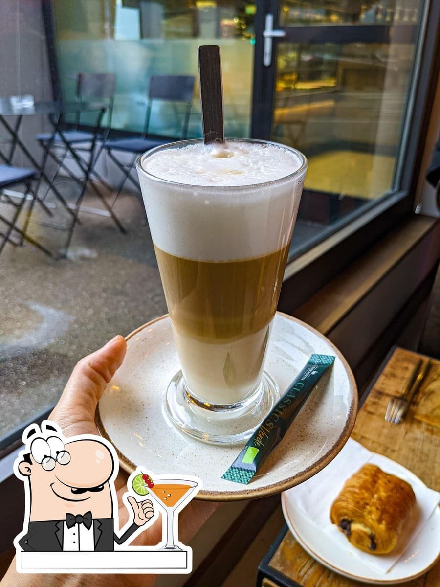 Cappuccino crémeux saupoudré de cacao, posé sur une soucoupe.